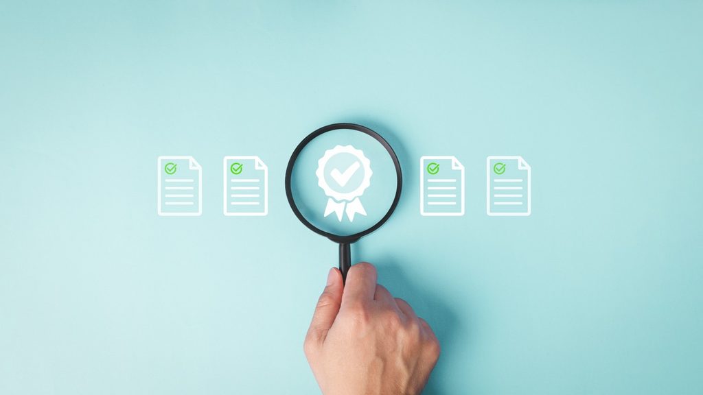 Main tenant une loupe au-dessus de documents de certification